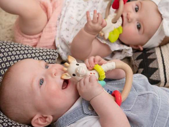 Des bébés avec des hochets dans la bouche